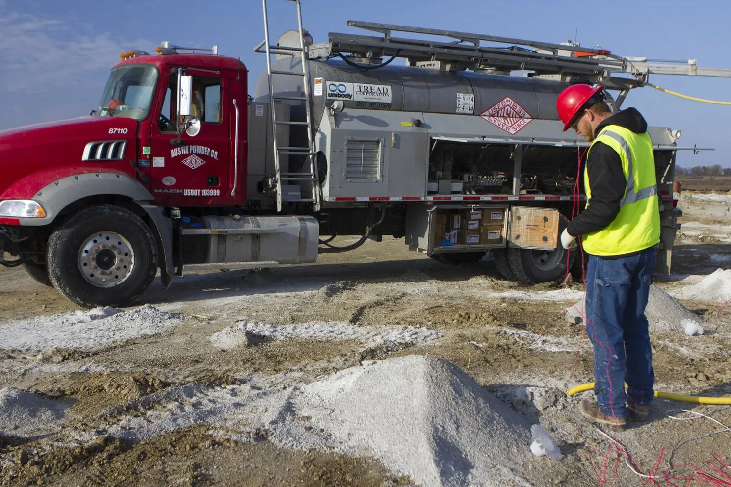 Blaster filing blast holes